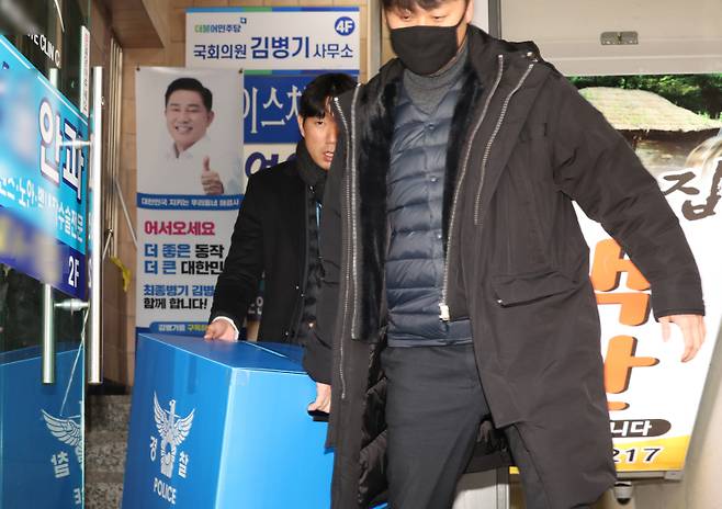 경찰이 14일 공천헌금 수수 등 각종 비위 의혹을 받는 더불어민주당 김병기 의원의 서울 동작구 지역구 사무실에서 압수수색을 마친 뒤 압수품 상자를 들고 나서고 있다. 연합뉴스