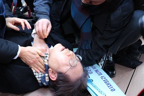 이재명, 가덕도 신공항부지 방문 일정 중 피습. 2024년 1월 2일 당시 더불어민주당 이재명 대표가 부산 가덕도 신공항 부지를 둘러본 후 기자들과 문답을 진행하던 중 왼쪽 목 부위에 습격을 당해 피를 흘린 채 쓰러져 있다.[연합뉴스]