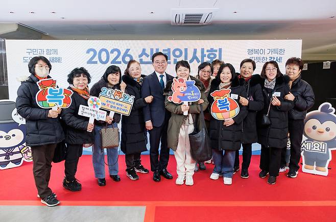 진교훈 강서구청장이 2026년 신년인사회에 참석한 주민들과 함께 서서 기념 촬영을 하고 있는 사진이다. 주민들은 ‘복’이라고 쓰인 복주머니 모형과 ‘새해 복 많이 받으세요’라고 적힌 팻말을 들고 있다.