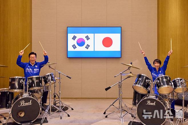 [나라=뉴시스] 고범준 기자 = 이재명 대통령이 다카이치 사나에 일본 총리와 함께 13일(현지 시간) 일본 나라현 회담장에서 일본 측이 마련한 푸른색 유니폼을 함께 착용하고 일본의 대표적인 악기 브랜드인 '펄' 드럼 앞에 나란히 앉아 즉석 드럼 합주를 선보이고 있다. (공동취재) 2026.01.13. bjko@newsis.com