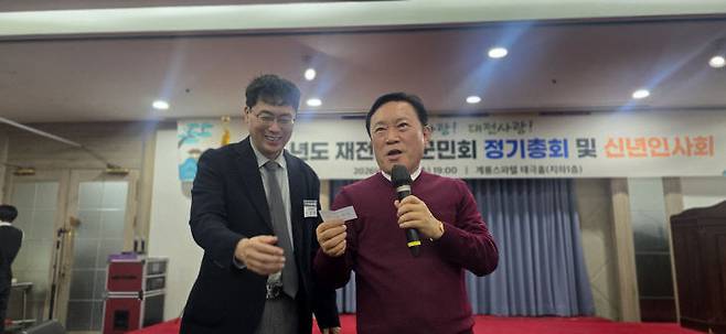 이장호 재전부여군민회 사무총장과 행운권 추첨하는 김원식 명예회장.