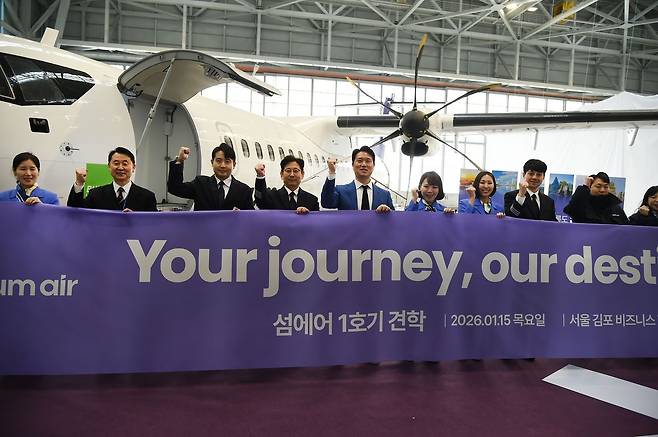 15일 서울 김포국제공항 격납고에서 열린 섬에어 1호기 도입식에서 최용덕 대표(왼쪽에서 다섯번째)가 직원들과 기념사진을 촬용하고 있다. 사진 섬에어