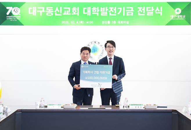 지난해 12월 대구동신교회 문대원(오른) 담임목사가 대구대 박순진 총장에게 기독학사 건립 발전기금을 전달한 뒤 기념촬영을 하고 있다. 대구대 제공