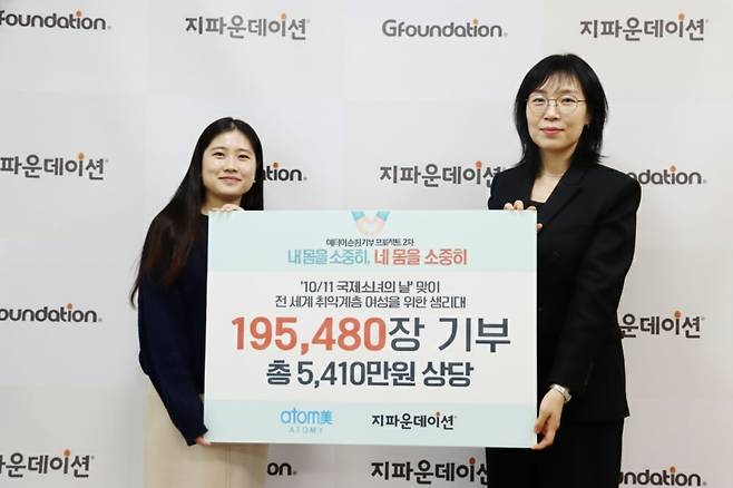 이은영 애터미 이사(오른쪽)과 배소진 지파운데이션 부장이 생리대 19만5480장 전달식 후 기념 사진을 찍고 있다. 애터미 제공