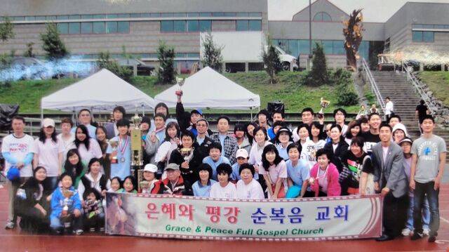 윤호용(앞줄 오른쪽에서 두 번째) 목사가 2012년 미국 알래스카에서 열린 ‘8·15 광복절 기념 한인 체육대회’에서 은혜와평강순복음교회의 종합 우승을 기념하며 교인들과 사진을 찍고 있다.