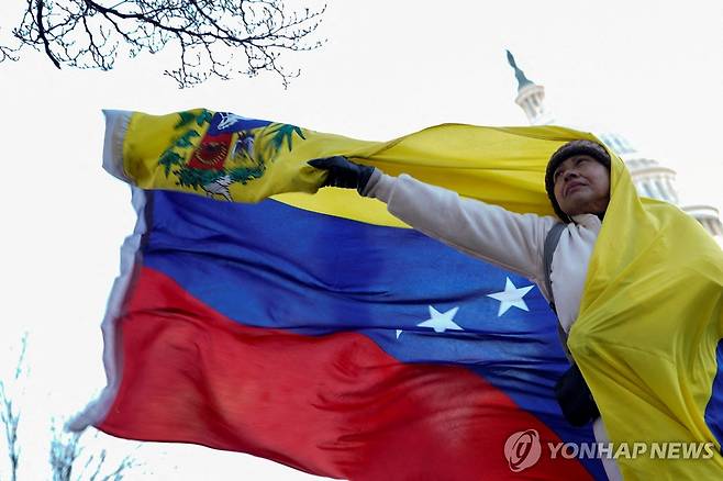 15일(현지시간) 미국 국회의사당 앞에서 베네수엘라 국기 펼치는 여성 [워싱턴 로이터=연합뉴스. 재판매 및 DB 금지]