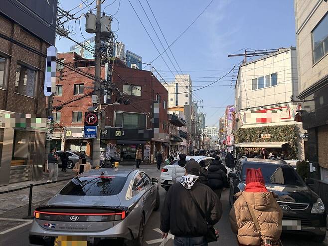 14일 서울 성동구 성수동 연무장길의 모습. 주정차된 자동차 옆으로 택시와 보행자들이 뒤섞여있다. /이호준 기자