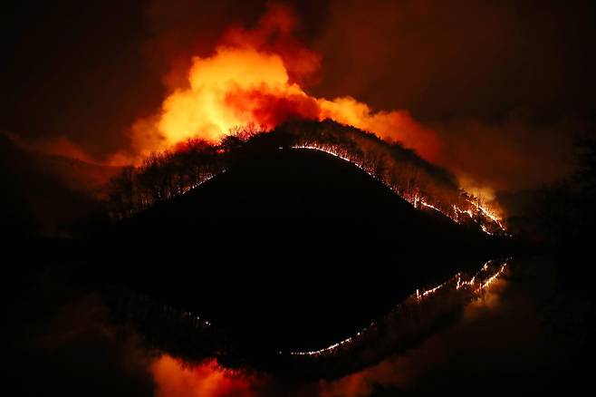 23일 오후 어둠이 짙게 깔린 경북 의성군 의성읍 업리 동사곡지(저수지) 뒤편 야산에 거대한 산불이 확산하고 있다. 2025.3.23/뉴스1