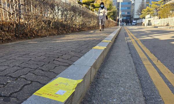 16일 오전 인천 남동구 인천경찰청 옆 인도 연석에 노란색 견인 이동 통지서가 줄줄히 붙어있다. 장민재기자