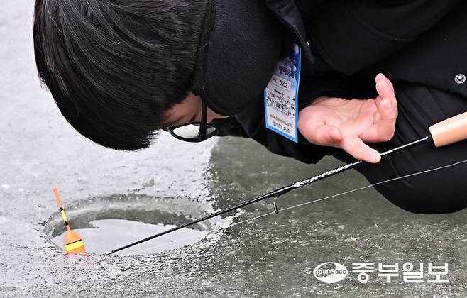 18일 오후 안성시 광혜원저수지 상류 일원에서 열린 웰컴투 동막골 안성빙어축제에서 한 어린이가 얼음 구멍을 유심히 바라보며 빙어 낚시를 즐기고 있다. 김경민기자