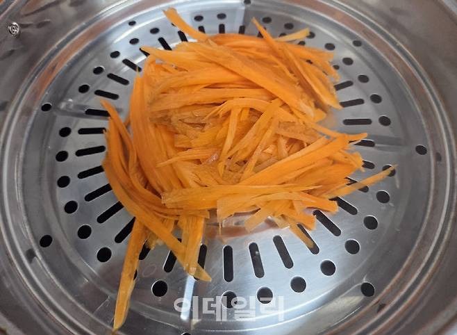 면 대신 사용할 당근을 일정한 굵기로 채 썬 뒤 찜기에 약 5분간 익힌 모습. 적당히 찌면 쫄깃한 식감이 살아난다. (사진=한전진 기자)