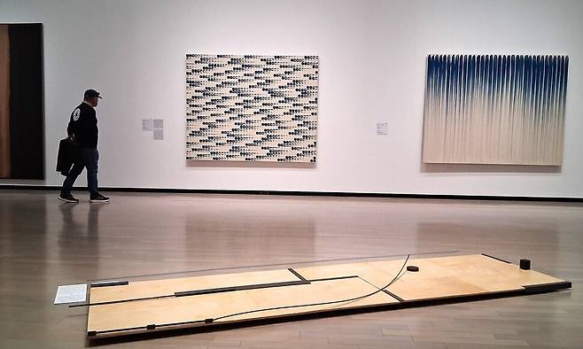 70년대 한국 일본의 미술교류상을 다룬 3섹션 전시장의 일부. 전시장 벽에 윤형근 작가의 76~77년작 ‘청다색’(맨 왼쪽)과 이우환 작가의 77년작 ‘점으로부터’‘선으로부터’ 연작들이 나란히 내걸렸다. 그 아래 바닥엔 1970년대 대구현대미술제에 출품했던 일본 작가 에비즈카 고이치의 설치작품 ‘조응-1977년 7월 대구의 여운’이 놓여져 있다. 노형석 기자