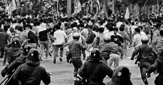 1989년 6월9일 새벽에 있었던 경찰의 압수수색을 규탄하는 서강대생 500여 명이 학교 정문 밖으로 나와 시위하자 경찰들이 각목과 쇠파이프 등을 휘두르며 학생들을 쫓고 있다.