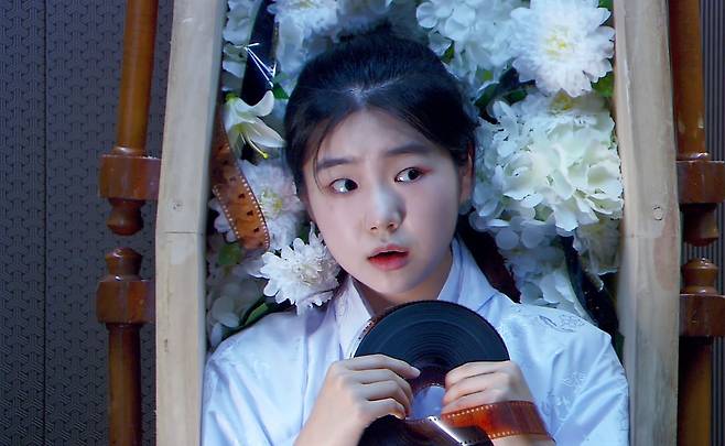 영화 '당신이 영화를 그만두면 안 되는 30가지 이유' 1막 Warm up 예열' 속 한 에피소드 '어느 날 영화가 죽었습니다'의 한 장면. 주인공 오영화가 뚜껑 열린 관에서 영화 필름을 손에 쥔 채 눈을 동그랗게 뜨고 주변을 살피고 있다. [사진 CJ ENM]