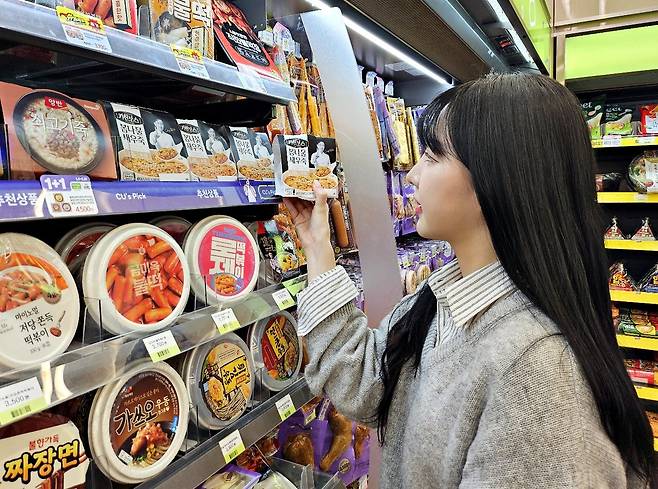 A shopper looks at products with the Netflix cooking reality show ″Culinary Class Wars″ (2024–) intellectual property brand at a CU convenience store. [BGF RETAIL]