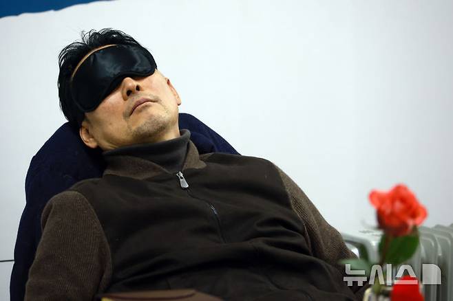 [서울=뉴시스] 고승민 기자 = 단식투쟁 4일차를 맞은 장동혁 국민의힘 대표가 18일 서울 여의도 국회 로텐더홀에서 안대를 쓰고 눈을 붙이고 있다. 2026.01.18. kkssmm99@newsis.com