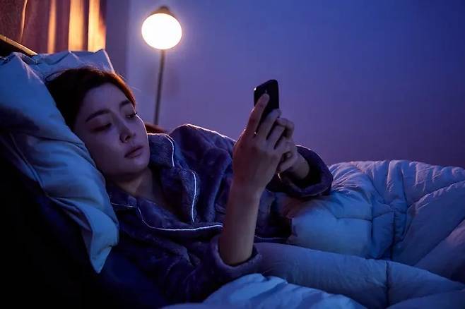 불을 끈 채 스마트폰 화면을 바라보는 습관은 동공을 과도하게 확장시켜 망막과 시신경에 큰 부담을 준다. 전문가들은 잠들기 전 어두운 환경에서의 스마트폰 사용을 눈 건강의 ‘위험 신호’로 꼽는다. 게티이미지