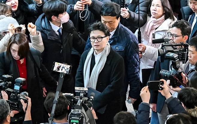Han Dong-hoon, former leader of the People Power Party, arrives at the National Assembly’s communication hall on Jan. 14 and heads to a press conference, cheered by supporters, to state his position on the ruling by the party’s central ethics committee to expel him. [LIM HYUN-DONG]