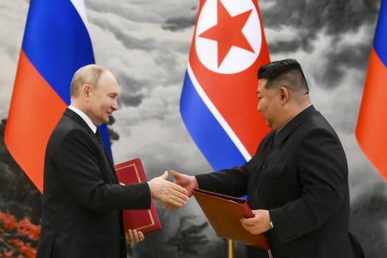 Russian President Vladimir Putin, left, and North Korea's leader Kim Jong-un exchange documents during a signing ceremony of their new partnership in Pyongyang, North Korea on June 19, 2024. [AP/YONHAP]