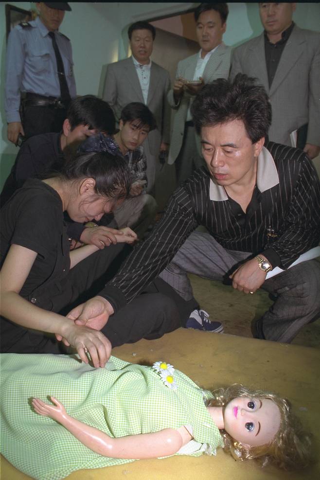 Jeon Hyeon-ju, left, reenacts the killing of 8-year-old Park Na-ri on Sept. 17, 1997. [JOONGANG ILBO]