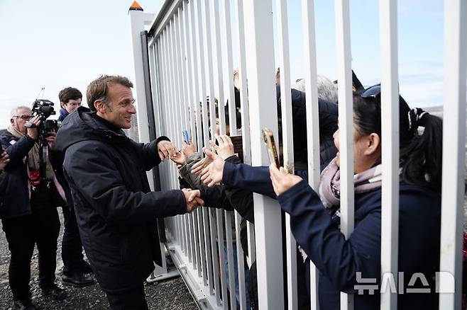 [누크=AP/뉴시스] 에마뉘엘 마크롱(왼쪽) 프랑스 대통령이 2025년 6월15일 그린란드 누크를 방문, 공항에서 현지 주민들과 인사를 나누고 있다. 마크롱 대통령은 덴마크 자치령 그린란드에 대해 "그린란드는 매물도 아니고 강제로 뺏을 수 있는 곳도 아니다"라고 밝혔고 트럼프의 추가 관세 위협에는 유럽연합 차원에서 대응할 생각이다. 2026. 01. 19.