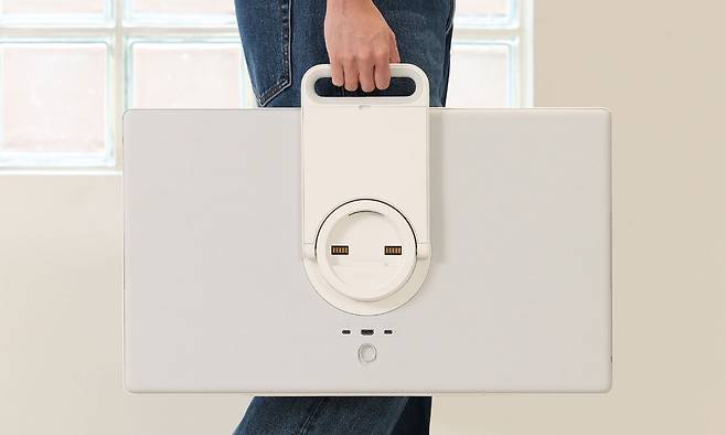 삼성전자의 이동형 스크린 ‘더 무빙스타일’을 스탠드에서 분리해 소지한 모습. 모니터에 장착된 ‘일체형 킥스탠드’를 손잡이로 활용해 들고 다닐 수 있다. 삼성전자 제공