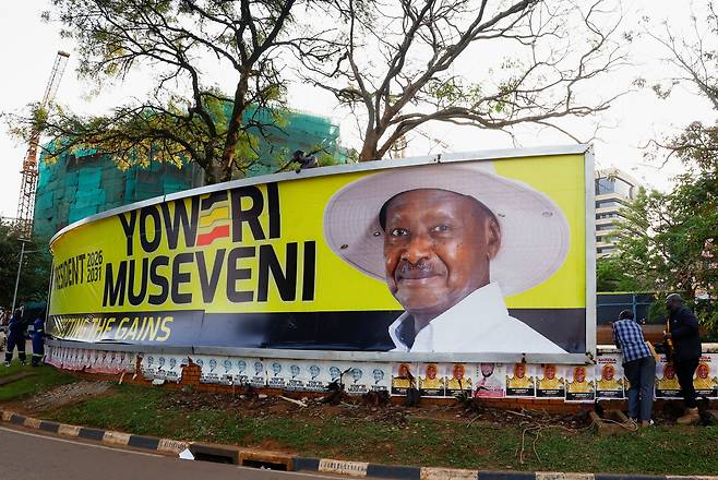 13일 우간다 캄팔라에서 총선을 앞두고 노동자들이 집권 국민저항운동(NRM)당 지도자인 요웨리 무세베니 우간다 대통령의 선거 홍보판을 설치하고 있다./로이터 연합뉴스