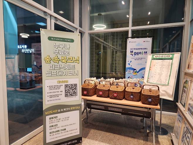 남산도서관 출입구에 '숲 속 북크닉' 피크닉 장비를 마련해 둬서 누구든&nbsp;대여할 수 있다. 지금은 겨울이라서 운영하지 않는다.