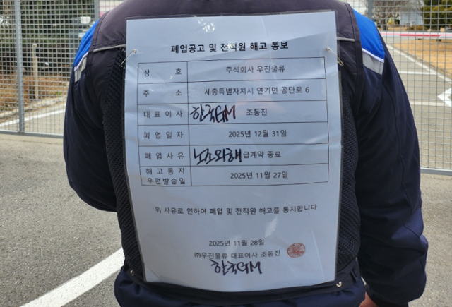 14일 한국GM 세종물류센터에서 만난 김용태 금속노조 GM부품물류지회장이 하청업체로부터 받은 '해고 통보문'을 몸에 붙이고 있는 모습. 대표이사와 폐업사유 항목은 원청인 한국GM의 책임을 강조하기 위해 큰 글씨로 일부 내용을 더했다. 송주용 기자