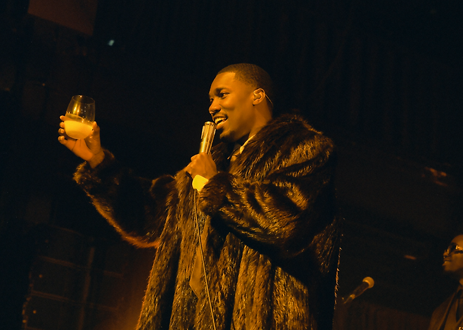 Giveon holds a glass of makgeolli — or Korean rice wine — during his performance of "Heartbreak Anniversary" at the "Dear Beloved" Seoul concert in Myungwha Live Hall, Sunday. (Live Nation Korea)
