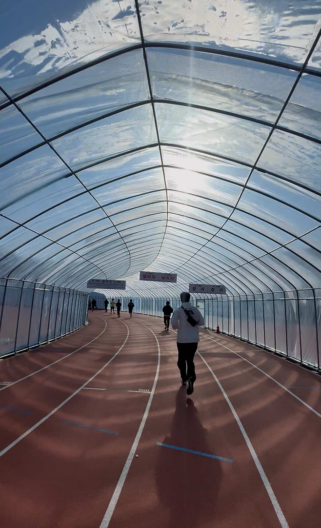 A greenhouselike plastic covering is installed over the public athletic track at Paju Stadium in Paju, Gyeonggi Province. (Kim Gi-hyun)