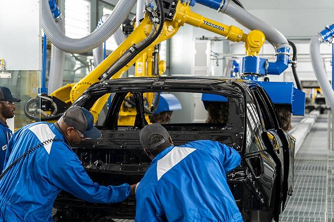 Workers are seen assembling an Ioniq 5 vehicle at the Hyundai Motor Group Metaplant America in Ellabell, Georgia. [HYUNDAI MOTOR]