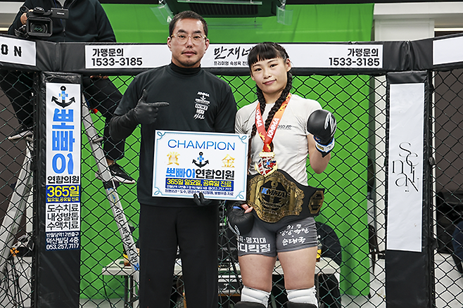 ‘유나코’ 고유나가 제2대 KMMA 여성부 플라이급 챔피언 기념 촬영을 하고 있다. 왼쪽은 킹덤주짓수구미봉곡 오주환 KMMA 심판장. 사진=뽀빠이연합의원KMMA파이터에이전시 제공