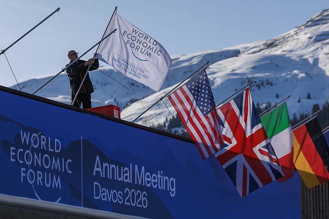 20일(현지시간) 스위스 다보스에서 열리는 제56차 세계경제포럼 연차총회 개막을 앞두고 사무국 직원이 각 국가의 국기와 사무국기를 게양하고 있다. 사무국은 올해 총회에 95개국이 참석한다고 밝힌 바 있다.  WEF