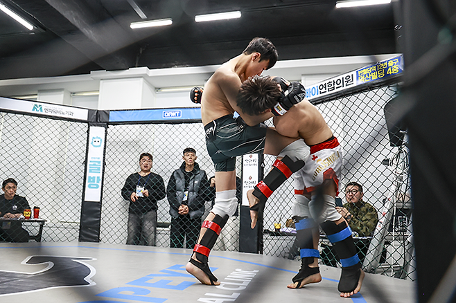 챔피언 변상민이 KMMA 밴텀급 타이틀 1차 방어전에서 도전자 오동현의 목을 잡고 상대 몸통을 향해 강력한 무릎 차기를 하고 있다. 사진=뽀빠이연합의원KMMA파이터에이전시 제공