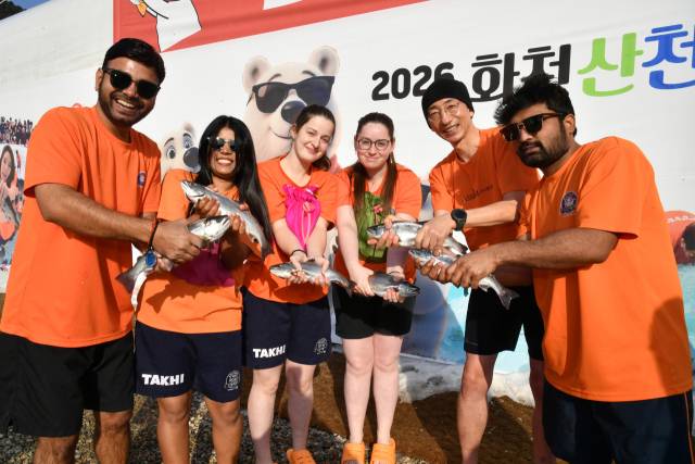 지난17일 강원도 화천군 화천천 일원에서 열린 2026 화천산천어축제 주요 행사인 산천어 맨손 잡기에 참가한 외국인 관광객이 산천어를 잡은 뒤 기념 촬영하고 있다. 사진 제공=화천군
