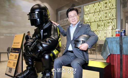 이재명 대통령이 지난해 10월 15일 서울 성동구 복합문화공간 펍지(PUBG) 성수에서 K-게임현장간담회를 갖기 전 크래프톤의 캐릭터 앞에서 헬멧을 들고 포즈를 취하고 있다. | 김창길 기자