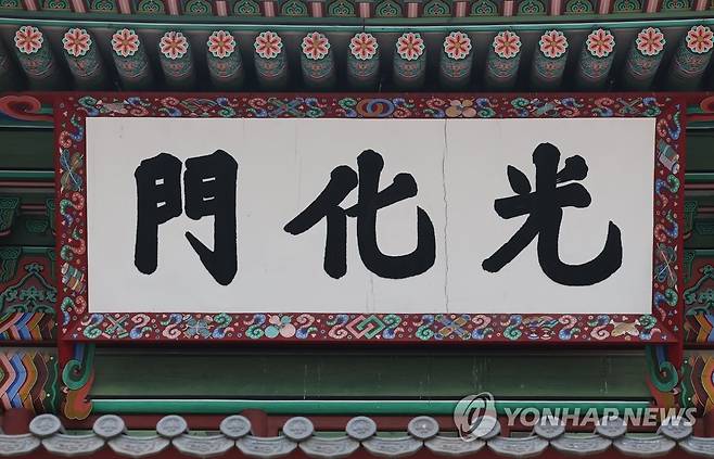 금이 간 광화문 현판 (서울=연합뉴스) 류영석 기자 = 경복궁 정문 광화문 현판에 균열이 일어나 교체를 촉구하는 시민단체의 주장에 문화재청은 새로 제작 중인 현판이 내년 하반기에 완성된다고 8일 밝혔다.
사진은 이날 오후 경복궁 정문 광화문 현판 모습. 현판의 '광'(光) 자와 '화'(化) 자 사이에 미세한 금이 보인다. 2022.6.8 ondol@yna.co.kr