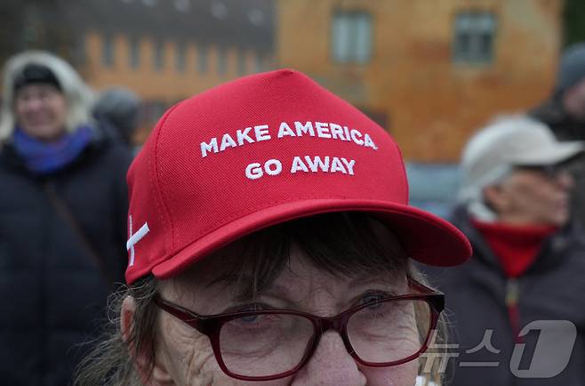 덴마크 수도 코펜하겐에서 미국의 그린란드 병합에 반대하는 시위자가 17일 '미국을 물러가게 하라'(Make America Go Away)라고 쓰인 모자를 쓰고 있다. 2026.1.17 ⓒ 로이터=뉴스1