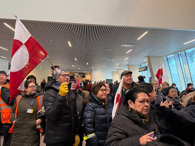 21일 그린란드 수도 누크공항에서 그린란드 자치령 깃발을 든 그린란드 사람들이 몰려나와 있다./원선우 특파원