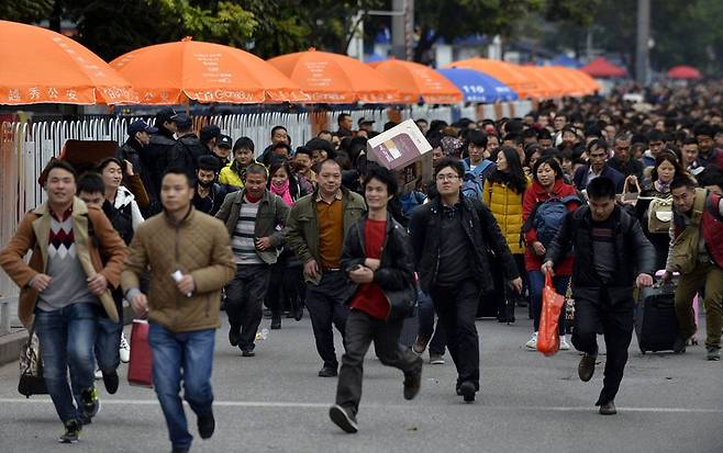 2020년 중국 남부 광동성 광저우 역 앞에서 사람들이 기차표 예매를 위한 줄을 서기 위해 달려가고 있다. /AFP 연합뉴스