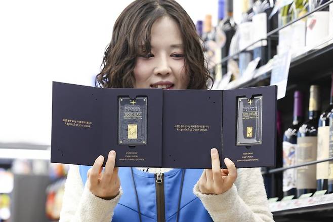 편의점 업계가 설 명절을 앞두고 고가 선물세트 경쟁에 돌입한 가운데 지난 14일 서울 강남구 GS25에서 직원이 금 제품을 들어보이고 있다. GS25는 금에 대한 꾸준한 인기를 반영해 역대 최다인 18종의 골드·실버 기획전을 진행한다. 뉴시스