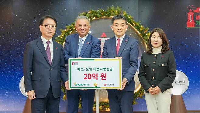 From left, Ryu Yul, the president of S-Oil; Anwar Al-Hejazi, the CEO of S-Oil; Hwang In-sik, the secretary general of the Community Chest of Korea (CCK); and Kim Kyung-hee, the chief of the social contribution division of CCK, pose for a photo at the CCK building in central Seoul on Jan. 21. [S-OIL]