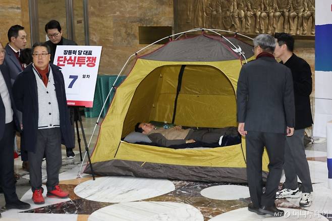 (서울=뉴스1) 이승배 기자 = 장동혁 국민의힘 대표가 21일 서울 여의도 국회 로텐더홀에서 더불어민주당의 통일교 및 공천뇌물 특검 수용을 촉구하며 7일째 단식을 이어가고 있다. 소방 구급대원들이 장 대표의 병원 이송을 위해 단식장에 출동했으나 이송 거부로 돌아갔다. 2026.1.21/뉴스1  Copyright (C) 뉴스1. All rights reserved. 무단 전재 및 재배포,  AI학습 이용 금지. /사진=(서울=뉴스1) 이승배 기자