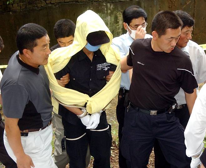 2004년 7월18일 유영철이 피해자의 사체를 유기한 서울 봉원사 인근에서 현장검증을 하고 있다. ⓒ사진공동취재단