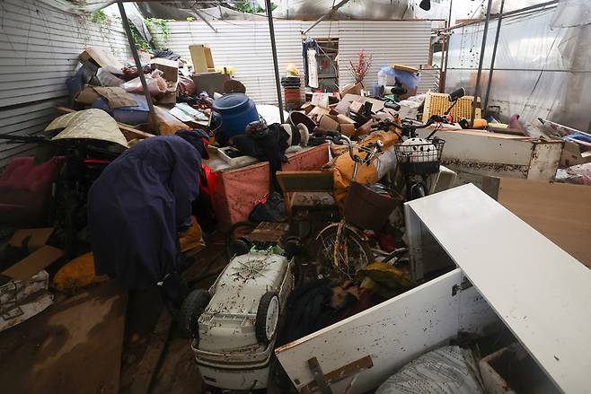 지난해 8월 13일 인천 계양구 병방동의 한 화훼농원에서 관계자가 흙탕물에 젖은 가재도구를 정리하고 있다. 2025.8.13 /연합뉴스