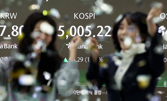 22일 오전 서울 중구 하나은행 본점 딜링룸 전광판에 코스피 지수가 5000포인트를 넘자 직원들이 환호하고 있다./뉴스1