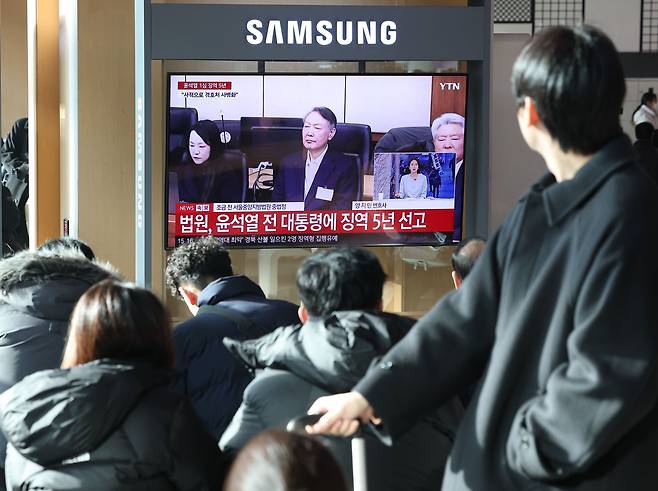 지난 16일 서울역 대합실에서 시민들이 고위공직자범죄수사처(공수처) 체포 방해 등 혐의로 기소된 윤석열 전 대통령에 대한 1심 선고 공판 생중계를 보고 있는 모습. 연합뉴스