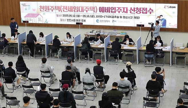 지난해 5월 인천시청 중앙홀에 마련된 천원주택 접수처에서 예비 신청자들이 줄지어 대기하고 있다. [연합뉴스]