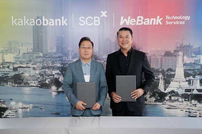 Kakao Bank CEO Yun Ho-young (left) and SCBX CEO Arthid Nanthawithaya pose after signing an agreement for joint venture investment in Bangkok on Wednesday. (Kakao Bank)